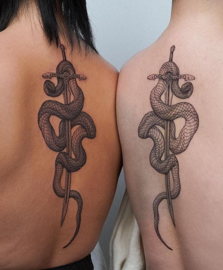 Snake and sword tattoo on his back 