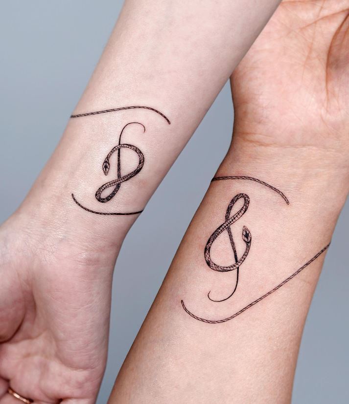 Snake musical note tattoo on the wrist 