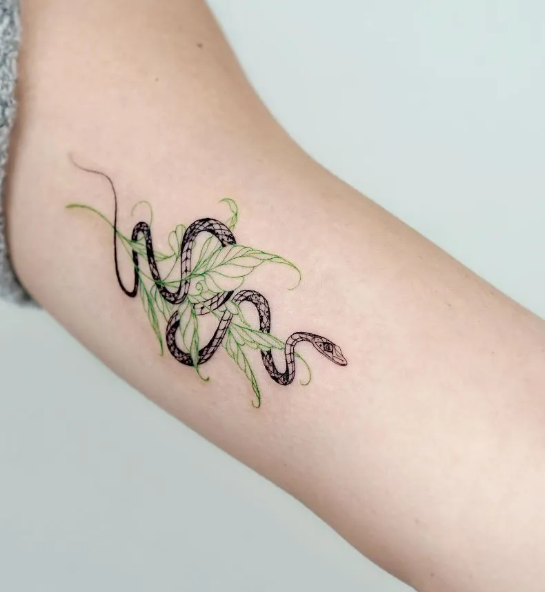 Minimalist tattoo in the form of a snake and green leaves 